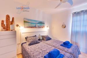 1 dormitorio con 1 cama con almohadas azules en Vivienda Vacacional El Tucan, en Tías