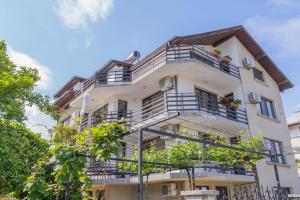a tall white building with balconies and trees at Vila Rosen in Lozenets +25 photos