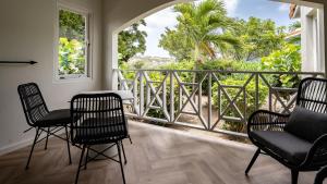 a room with chairs and a balcony with a view at Blue Bay Lodges in Willemstad