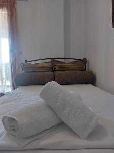 a bed with two towels and a pillow on it at Kostas Apartments in Ierissos