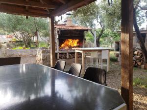 a table and chairs with a fireplace in a yard at Apartmani Maria in Preko