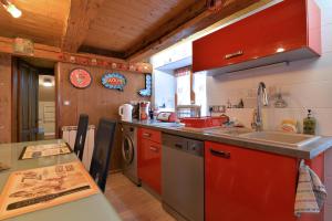 a kitchen with red cabinets and a sink at Gîte de la Chapelle des Mineurs in Sainte-Marie-aux-Mines