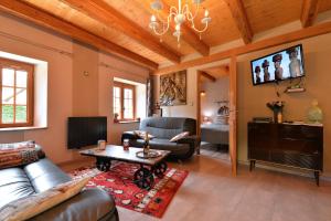 a living room with a couch and a tv at Gîte de la Chapelle des Mineurs in Sainte-Marie-aux-Mines