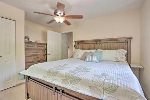 Un dormitorio con una cama grande con ventilador de techo. en Patio and Grill Lake of the Ozarks Escape!, en Roach