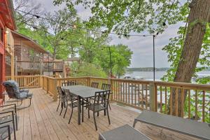 a wooden deck with a table and chairs on it at Private Boat Slip Serene Lake of the Ozarks Home in Lake Ozark