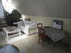 a living room with a couch and a table at les volets bleus in Saint-Guénolé