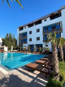 un hotel con piscina y un edificio en Hotel Athina, en Velipojë