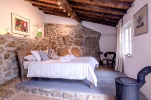 Un dormitorio con una cama y una pared de piedra. en Special Farmstay, Faia-Guarda, en Faia 61 fotos más