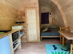 a small room with a bed in a wooden cabin at Camping du lac in Saint-Julien-du-Verdon