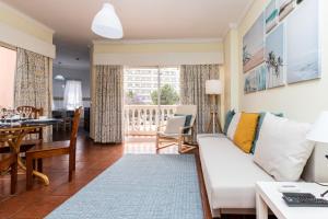 ein Wohnzimmer mit einem weißen Sofa und einem Esszimmer in der Unterkunft Parque dos Reis Apartment 2 in Monte Gordo