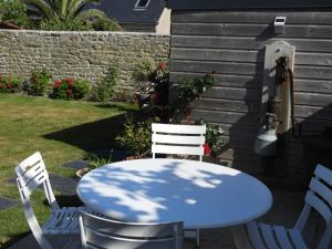 a blue table and two chairs in a yard at les volets bleus in Saint-Guénolé