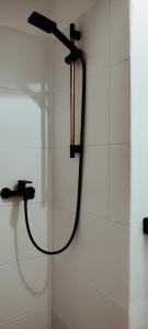 een douche met een slang aan een muur bij ArLange in Ventspils
