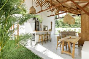 an open kitchen and dining room with a table and chairs at The Bingin Beach Villas' Private Villas in Uluwatu