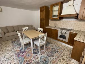 a kitchen with a table and chairs and a couch at Trulli Ulivi in Putignano