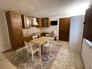 Il comprend une cuisine avec une table et des chaises en bois. dans l'établissement Trulli Ulivi, à Putignano
