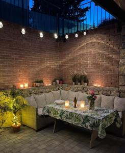 a patio with a table and a couch and candles at Emifüred in Balatonfüred