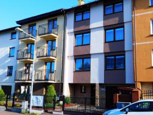 apartamentowiec z balkonami i samochód zaparkowany przed budynkiem w obiekcie Family Homes - Dom Wakacyjny EDA we Władysławowie