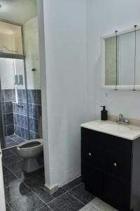 a bathroom with a toilet and a sink and a mirror at 5 VENATOR House Boutique in León
