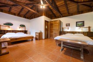 a bedroom with two beds and a wooden ceiling at Rancho Margot Sustainable & Self Sufficient Eco Lodge in El Castillo de La Fortuna