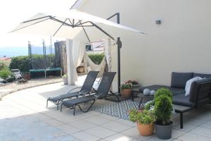 un patio con sofá y sillas bajo una sombrilla en Villa Lente, en Polje