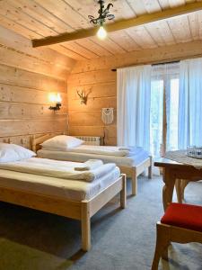 a bedroom with two beds in a wooden cabin at Pokoje Maria Mąka in Zakopane