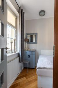 um quarto com uma cama e uma janela em Apartament Kowalska Starówka em Elblag