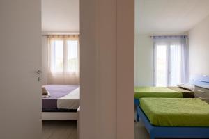 Un dormitorio con dos camas y dos ventanas. en casa romy, en Lotzorai