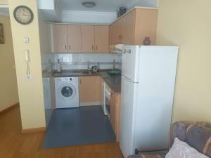 a kitchen with a white refrigerator and a washing machine at Apartamento Jardin del Sueve in Colunga