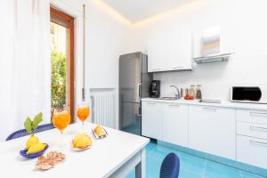 索倫托的住宿－Blu Oltre，厨房配有白色橱柜和水果桌