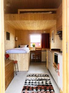 Sigurdbua في Kvalnes: غرفة نوم بسرير ومطبخ مع طاولة
