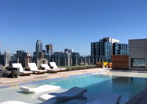 una piscina con tumbonas y vistas al perfil urbano en Brand New - Spacious Luxury Condo, Steps from Lake & Rainey for 4 en Austin