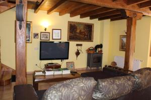 Il comprend un salon doté d'un canapé et d'une télévision à écran plat. dans l'établissement Vivienda vacacional La Güera - Casas de los Picos, à San Esteban