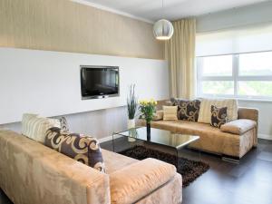 ein Wohnzimmer mit 2 Sofas und einem TV in der Unterkunft Apartamenty KTW Dębowe Tarasy in Kattowitz