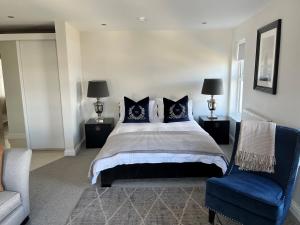 a bedroom with a large bed and a blue chair at Seafront Luxury Apartment in Cleethorpes
