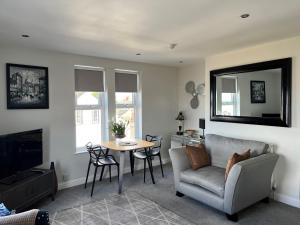 a living room with a table and a couch and a television at Seafront Luxury Apartment in Cleethorpes