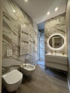 La salle de bains est pourvue de toilettes, d'un lavabo et d'un miroir. dans l'établissement SUMMER PARADISE, à Bari