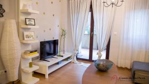 uma sala de estar com uma televisão de ecrã plano num suporte em Apartamento El Soplao - Casas de los Picos em Celis