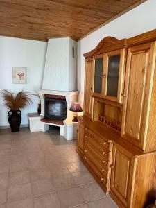 a living room with a fireplace and a television at Приятна къща за почивка Караколев 2 in Obrochishte