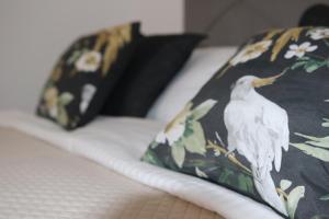 a bed with a pillow with a white bird on it at CASA VERDE Comfortable Air-Conditioned Modern Apartments in Ingenio
