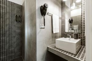 La salle de bains est pourvue d'un lavabo et d'un téléphone mural. dans l'établissement B&B LUMAS, à Rome