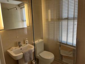 a bathroom with a white toilet and a sink at Seafront Luxury Apartment in Cleethorpes