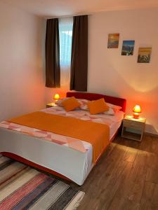 a bedroom with a bed with two lamps on it at Apartmani Mateja in Kaštela
