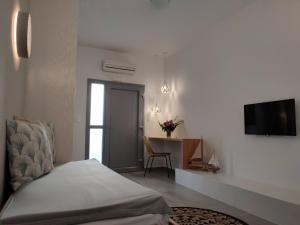 a bedroom with a bed and a desk with a television at Drimoni Boutique in Ios Chora