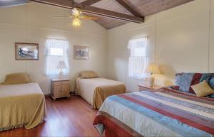 1 dormitorio con 2 camas y 2 ventanas en Banning House of Two Harbors en Two Harbors