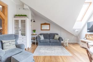 ein Wohnzimmer mit 2 Stühlen und einem Sofa in der Unterkunft Apartament Wigilijna Premium Starówka in Elblag