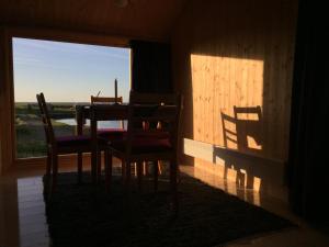 ein Esszimmer mit einem Tisch, 2 Stühlen und einem Fenster in der Unterkunft Fisherman's cabin in Kvalnes