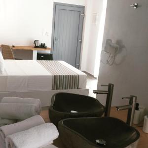 sypialnia z 2 łóżkami, krzesłem i łóżkiem w obiekcie Drimoni Boutique w mieście Ios (Chora)