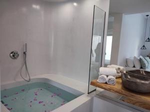 a bathroom with a tub and a shower with a sink at Drimoni Boutique in Ios Chora +76 photos
