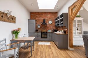 a kitchen with gray cabinets and a brick wall at Apartament Wigilijna Premium Starówka in Elblag