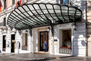 a man standing in the doorway of a building at Baglioni Hotel Regina - The Leading Hotels of the World in Rome